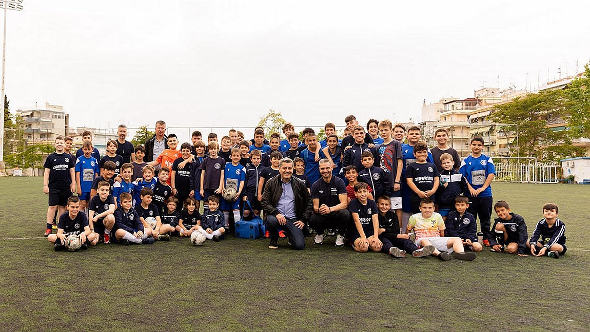 Ο Άγγελος Χαριστέας, Πρωταθλητής Ευρώπης Euro 2004, και ο Οδυσσέας Χριστοφόρου, Αναπληρωτής Διευθύνων Σύμβουλος ΟΠΑΠ, με τα παιδιά της ακαδημίας ποδοσφαίρου 'Αχιλλέας Τριανδρίας'
